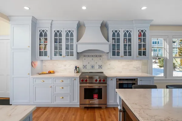 a kitchen with stainless steel appliances granite countertop a stove and a white cabinets