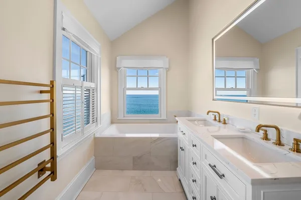 a bathroom with a bathtub a sink a vanity and a window