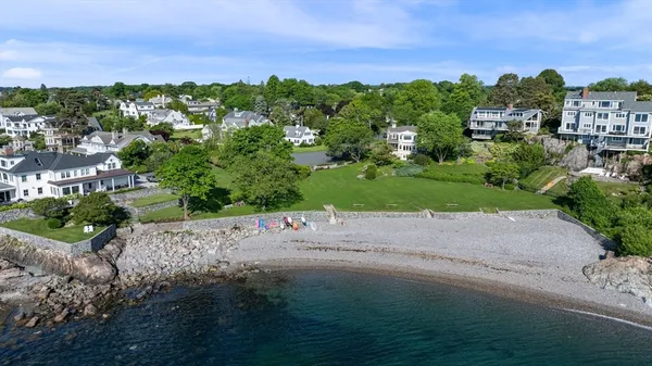 an aerial view of a houses with a yard and lake view