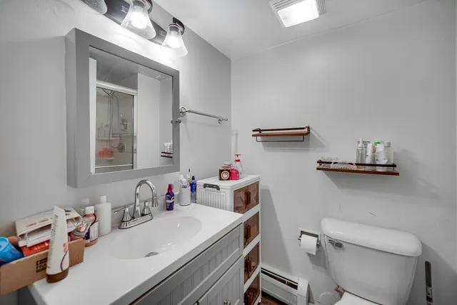 a bathroom with a sink vanity mirror and toilet