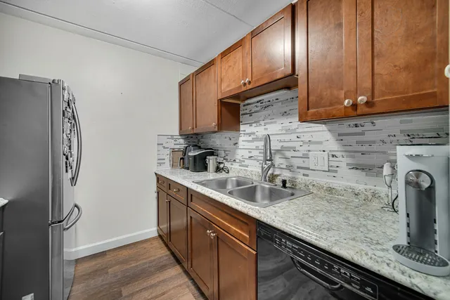 a kitchen with stainless steel appliances granite countertop a sink a stove and a refrigerator