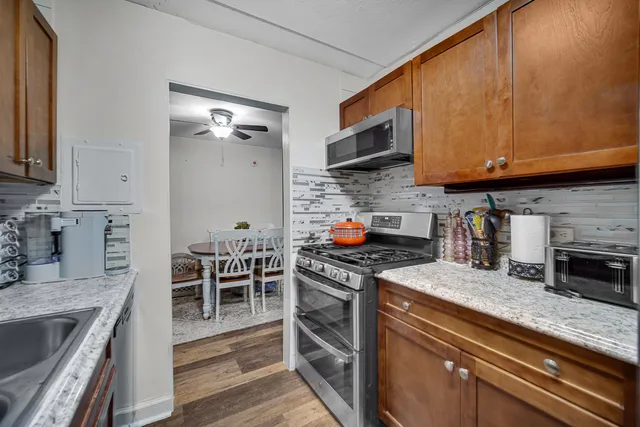 a kitchen with stainless steel appliances granite countertop a stove a sink and a microwave