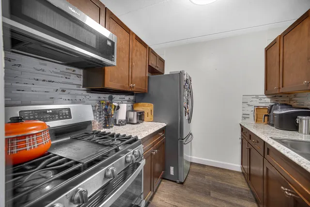 a kitchen with stainless steel appliances granite countertop a stove and a refrigerator