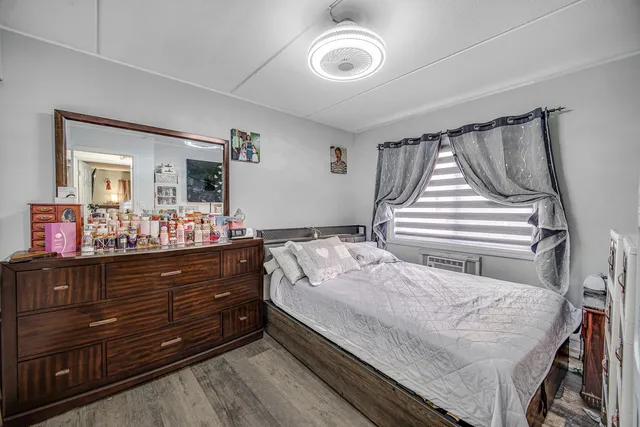 a bedroom with a bed and a mirror on dresser