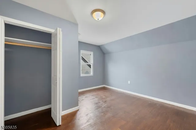 an empty room with a fan & a window