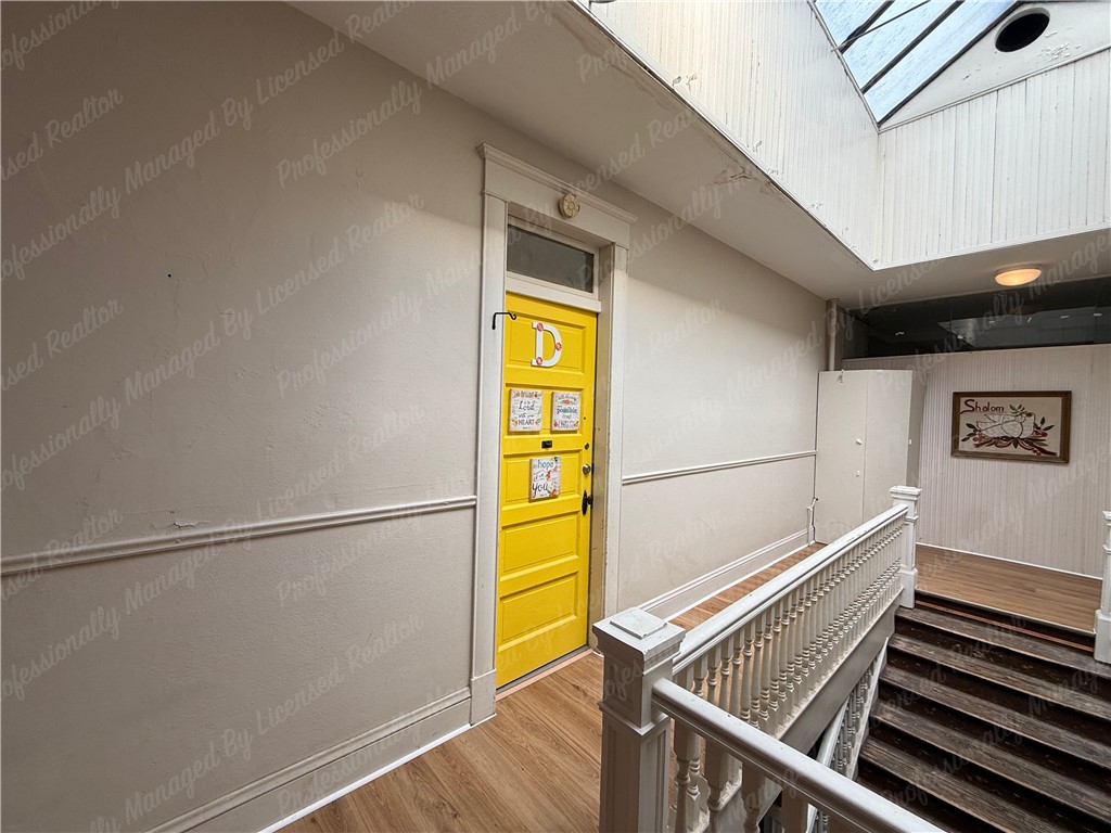 44 West High Street, Unit D Springfield, OH 45502 - Photo 4 of 25 This interior hallway features a brightly painted door, leading to a charming upper level.