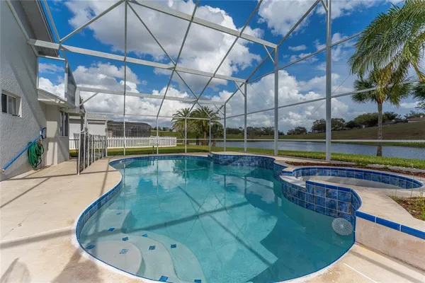a view of a swimming pool with a patio and a yard