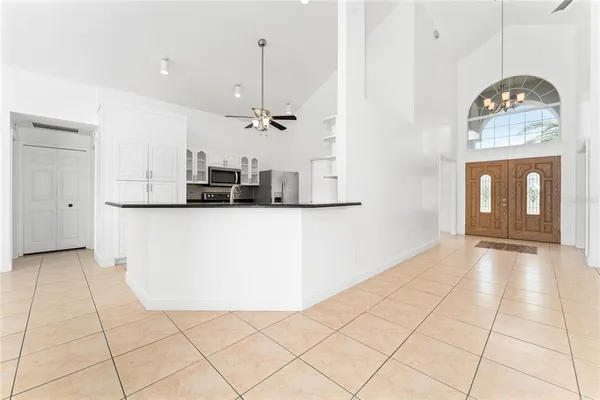 a view of a kitchen with kitchen island granite countertop stainless steel appliances cabinets a sink and a counter top space