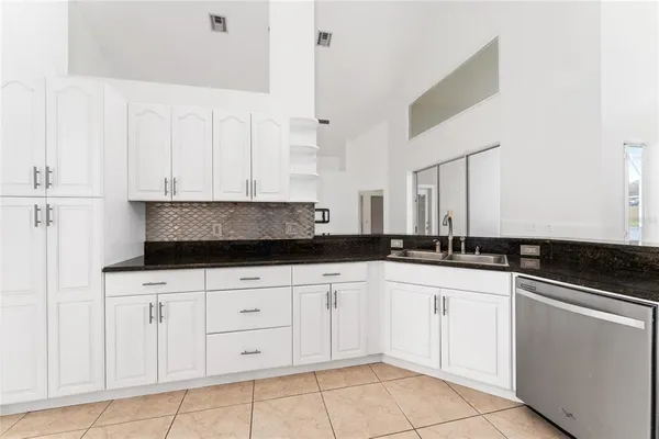 a kitchen with white cabinets and appliances