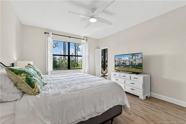 a bedroom with a bed television window and dresser