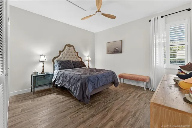 a bedroom with a bed wooden floor and window
