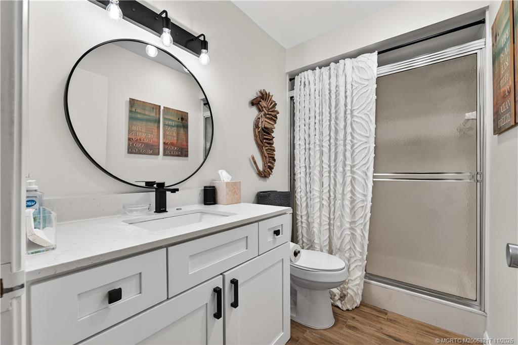 13438 Northwest Harbour Ridge Boulevard, Unit 3A Palm City, FL 34990 - Photo 17 of 19 a bathroom with a toilet a sink and a mirror