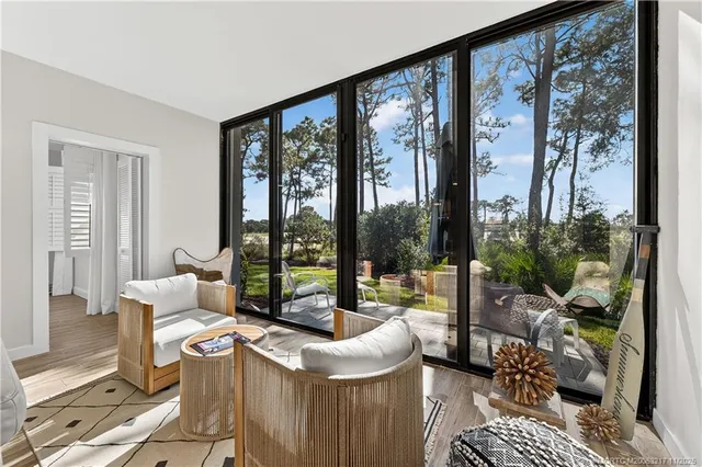 a living room with furniture and a floor to ceiling window