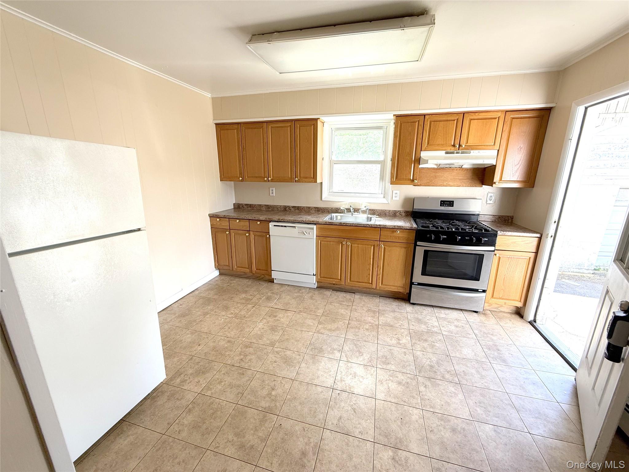 a kitchen with stainless steel appliances granite countertop a stove a sink and a refrigerator