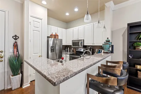 a kitchen with stainless steel appliances granite countertop a sink and a counter top space