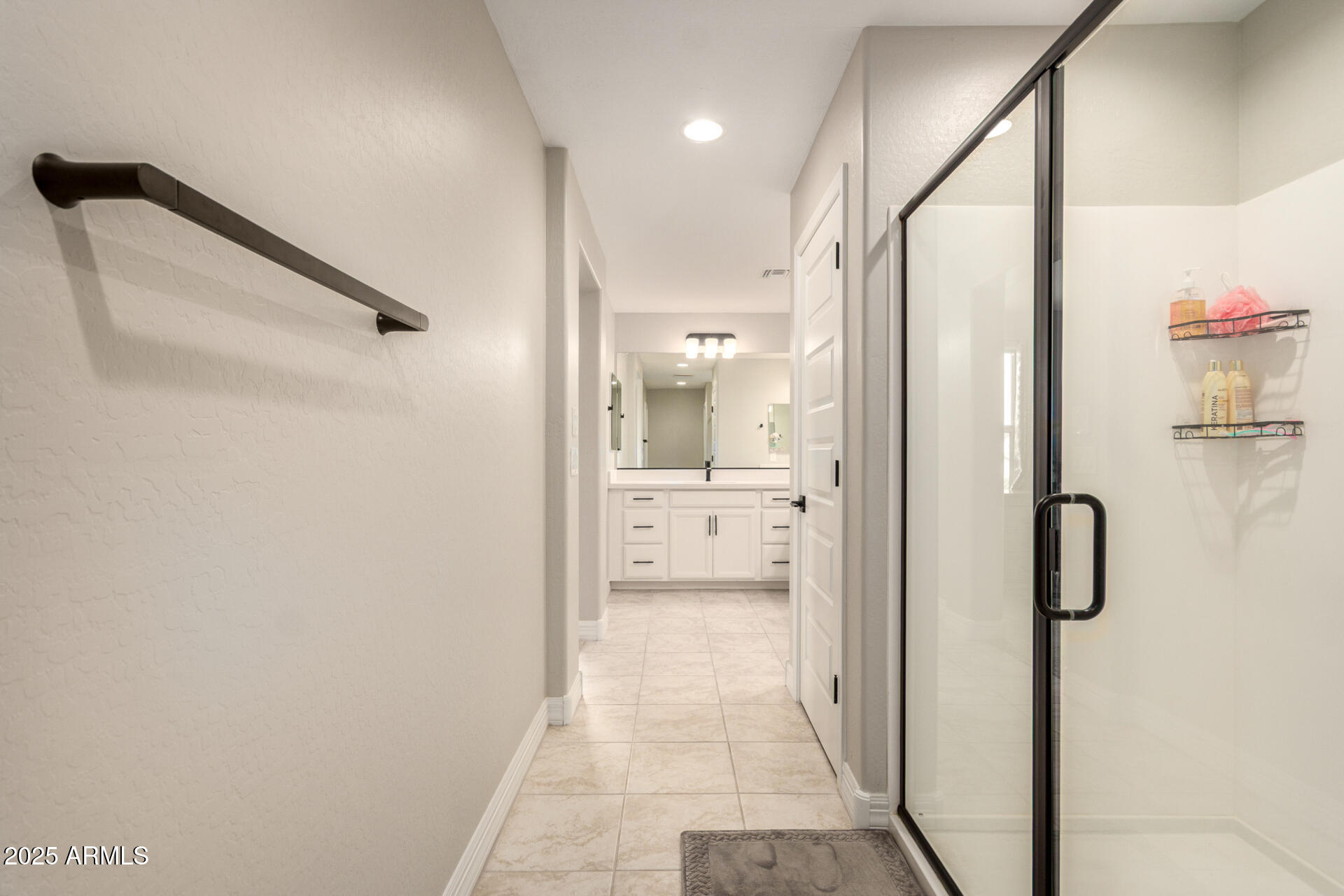 5126 West Roundhouse Road Laveen, AZ 85339 - Photo 25 of 39 a bathroom with a glass shower door
