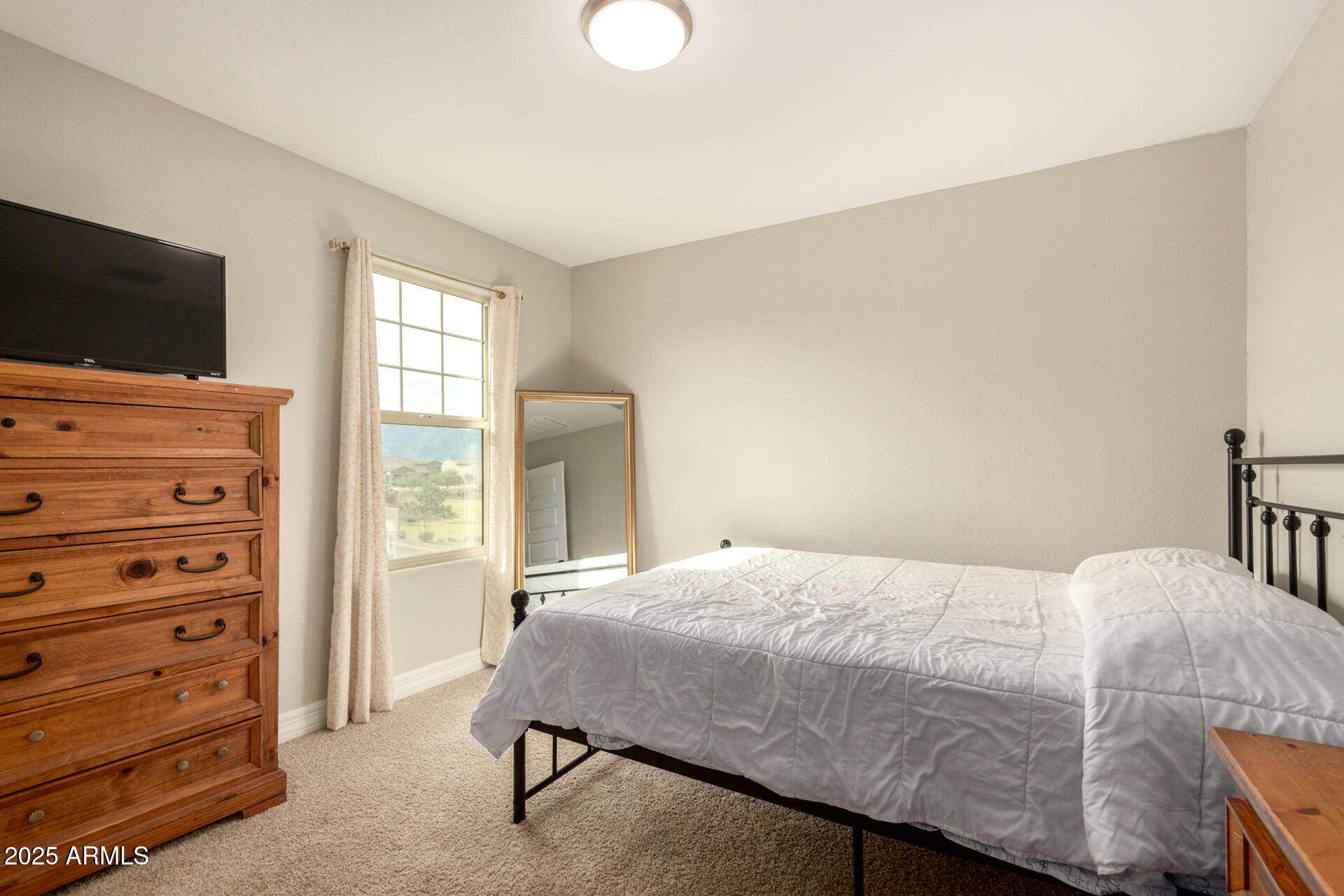 5126 West Roundhouse Road Laveen, AZ 85339 - Photo 29 of 39 a bedroom with a bed and flat screen tv