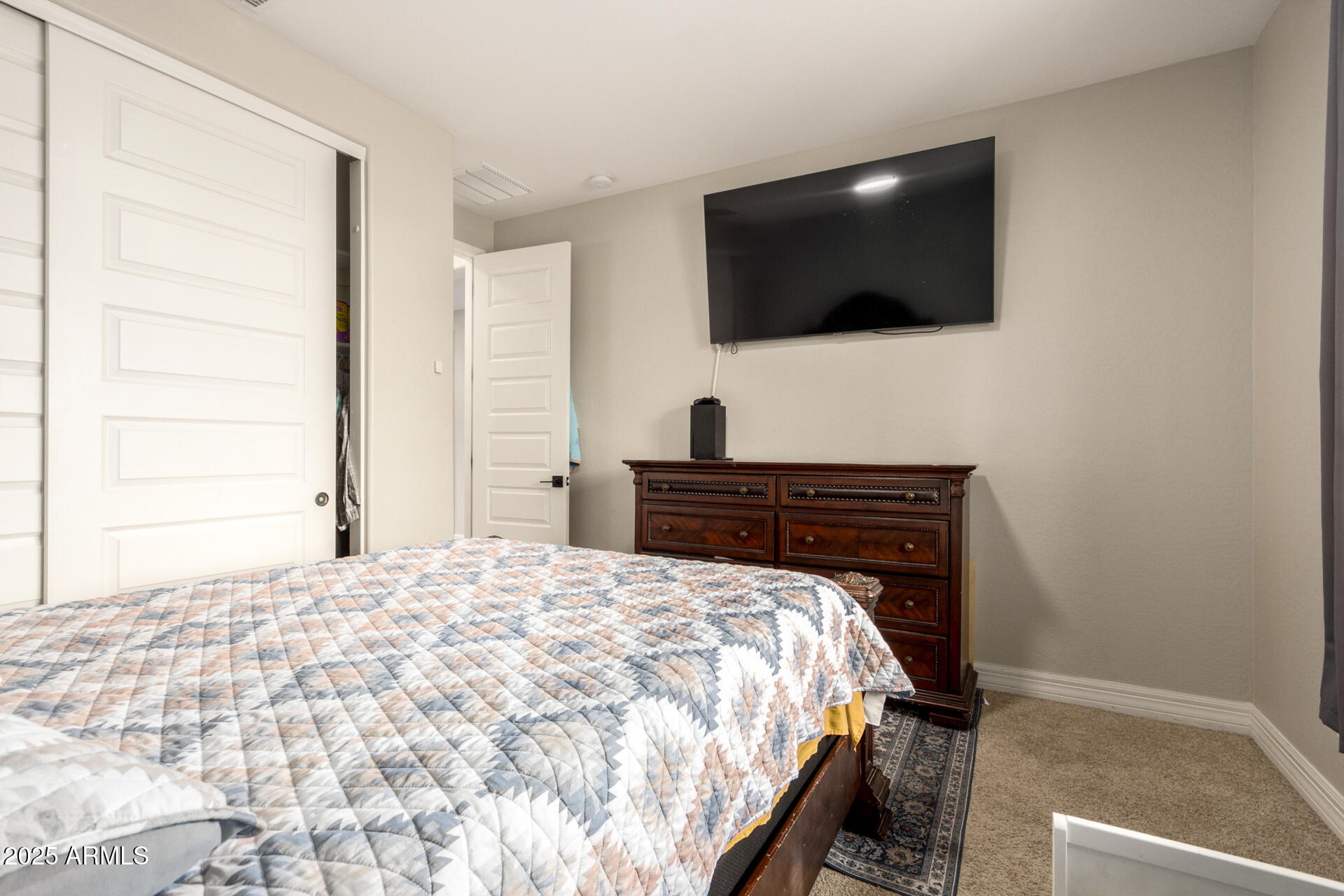 5126 West Roundhouse Road Laveen, AZ 85339 - Photo 35 of 39 a bedroom with a bed and a flat screen tv