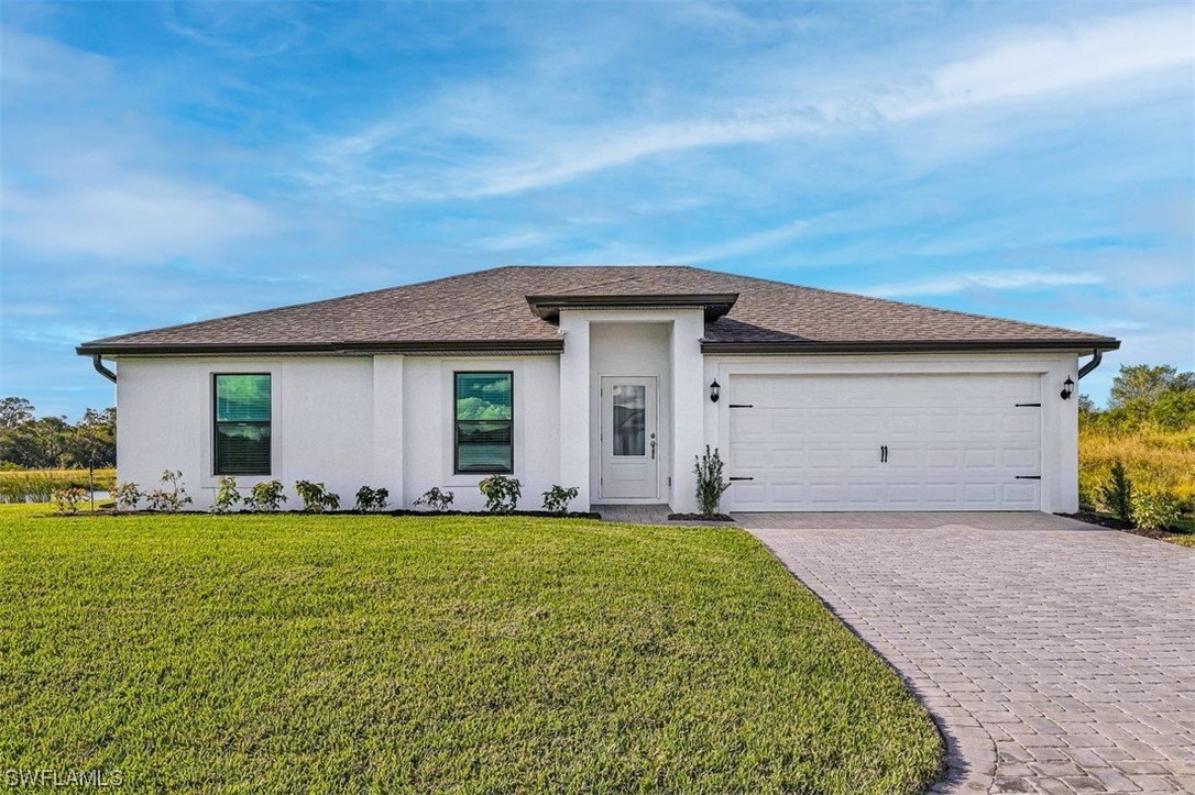 a front view of house with yard and garage