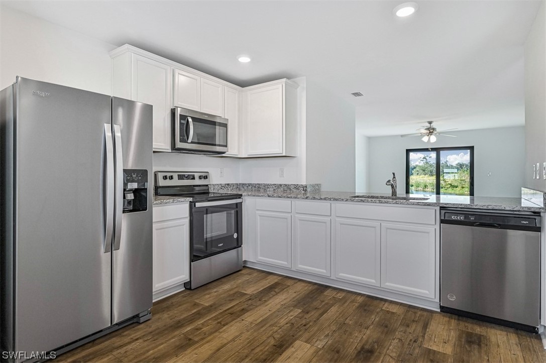 880 General Chesty Puller Court LaBelle, FL 33935 - Photo 9 of 21 a kitchen with stainless steel appliances granite countertop a stove a sink and a refrigerator