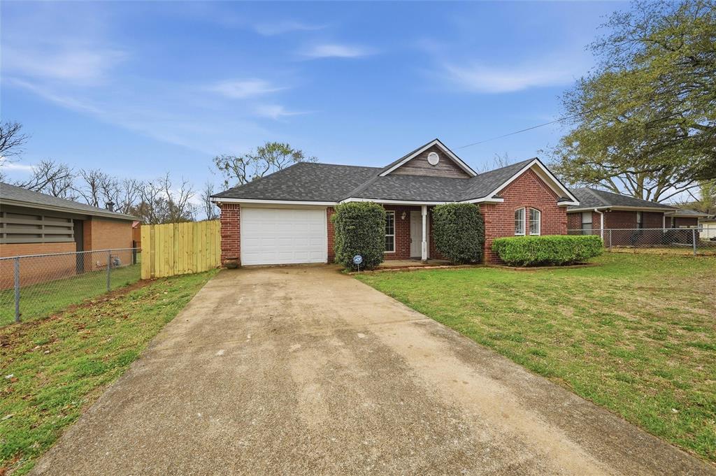 2418 Loy Lake Road Denison, TX 75020 - Photo 2 of 23 a front view of a house with a yard and garage