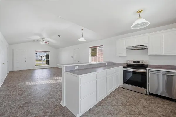 a kitchen with stainless steel appliances granite countertop a stove a refrigerator and a sink