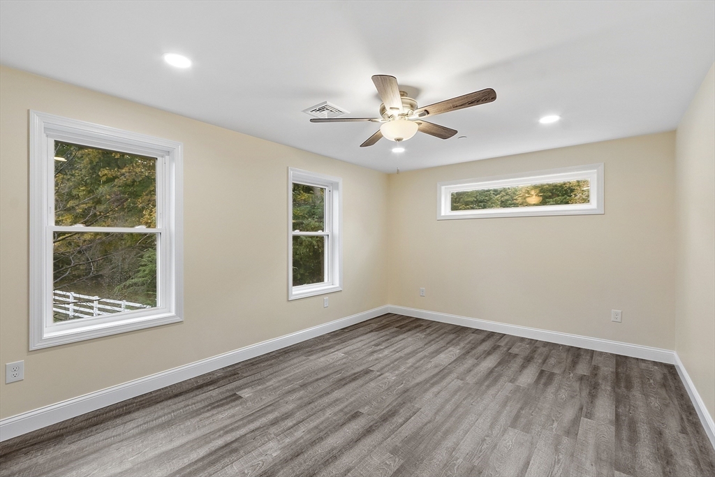 20 Townsend Street, Unit 1 Pepperell, MA 01463 - Photo 15 of 25 a view of an empty room with a window and wooden floor