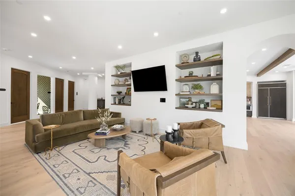a living room with furniture a flat screen tv and a large window