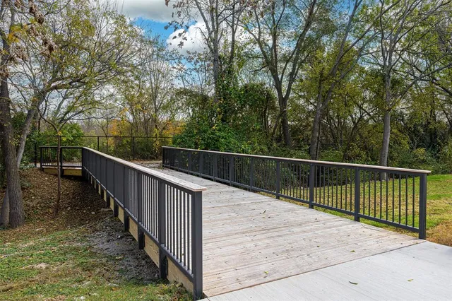a view of a balcony with wooden fence and trees