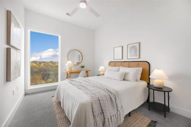 a bedroom with a bed and a large window