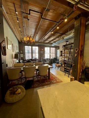 a room with lots of chairs a chandelier and pool table
