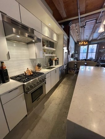 35 Channel Center Street, Unit 211 Boston, MA 02210 - Photo 7 of 11 a kitchen with stainless steel appliances granite countertop a sink a stove and a refrigerator