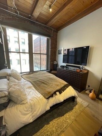 35 Channel Center Street, Unit 211 Boston, MA 02210 - Photo 10 of 11 a bedroom with a bed and wooden floor
