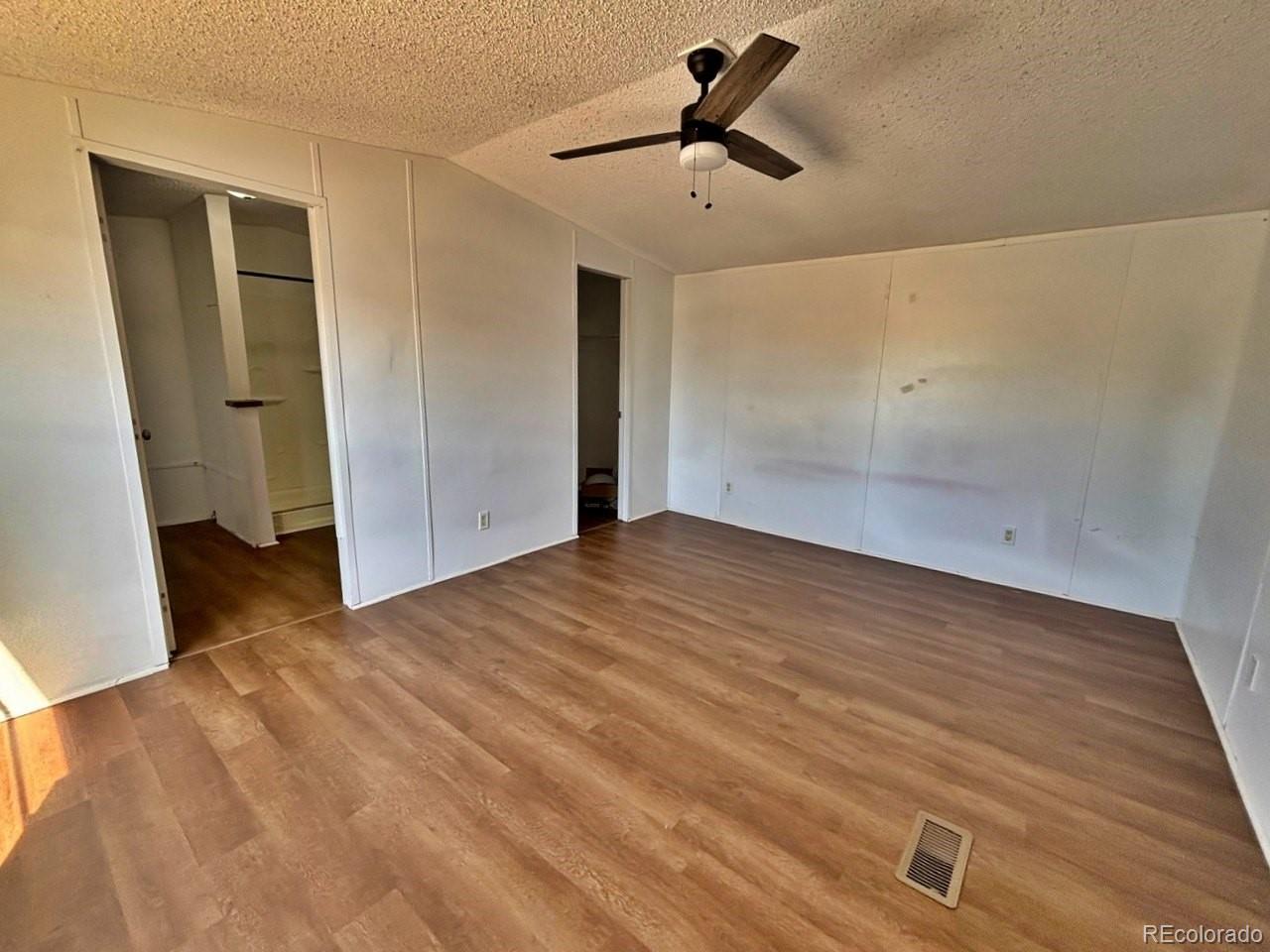 1205 Reed Lane La Junta, CO 81050 - Photo 12 of 26 a view of empty room with wooden floor and ceiling fan