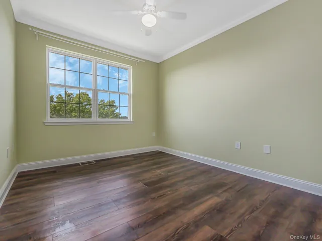 an empty room with wooden floor and window