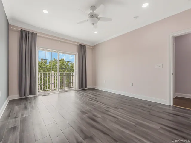 a view of a room with wooden floor and a ceiling fan