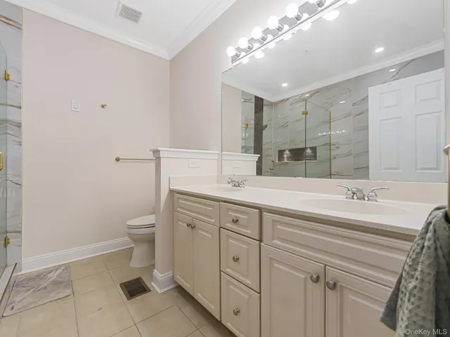 a spacious bathroom with a granite countertop sink a toilet and a mirror