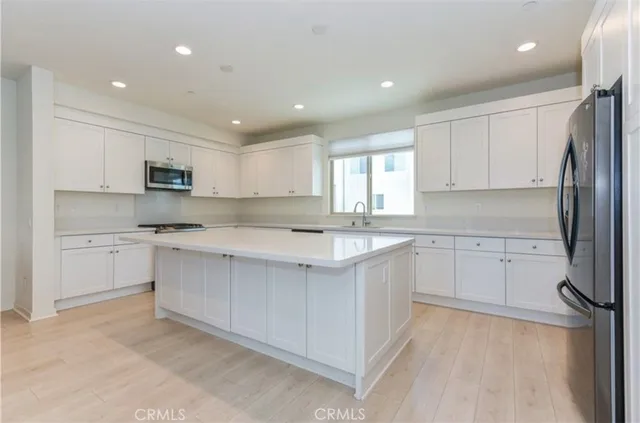 a kitchen with white cabinets and stainless steel appliances