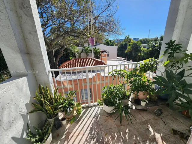 a view of balcony with wooden floor and potted plants