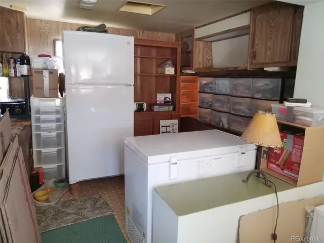 a kitchen with a refrigerator and a stove top oven