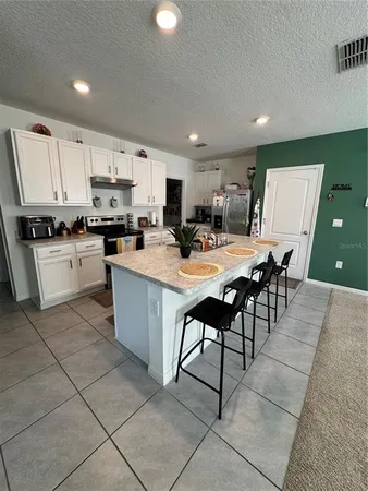 a kitchen with stainless steel appliances granite countertop a stove a sink a microwave and a refrigerator