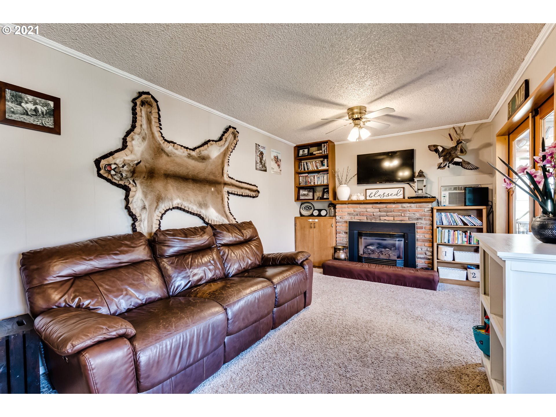 2488 37th Street Springfield, OR 97477 - Photo 14 of 32 a living room with furniture a flat screen tv and a fireplace
