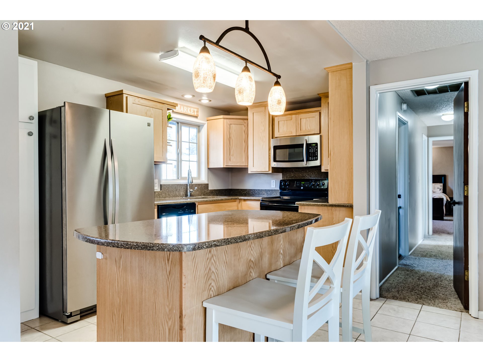 2488 37th Street Springfield, OR 97477 - Photo 7 of 32 a kitchen with stainless steel appliances granite countertop a refrigerator a stove and a sink with wooden floor