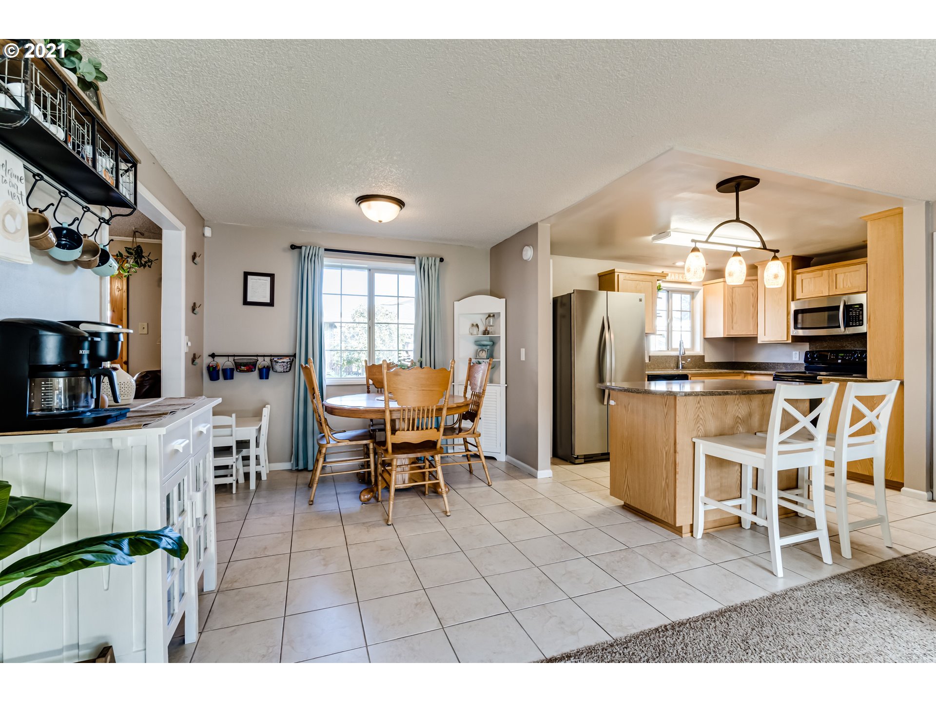 2488 37th Street Springfield, OR 97477 - Photo 8 of 32 a view of a dining room with furniture a kitchen and chandelier