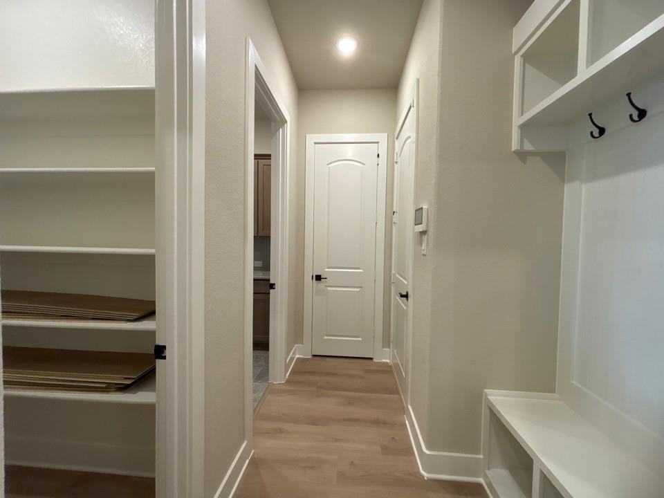 912 Creekview Whites Road Van Alstyne, TX 75495 - Photo 8 of 13 Wood-finish flooring, built-in shelving, white paneled doors, and a built-in bench with storage