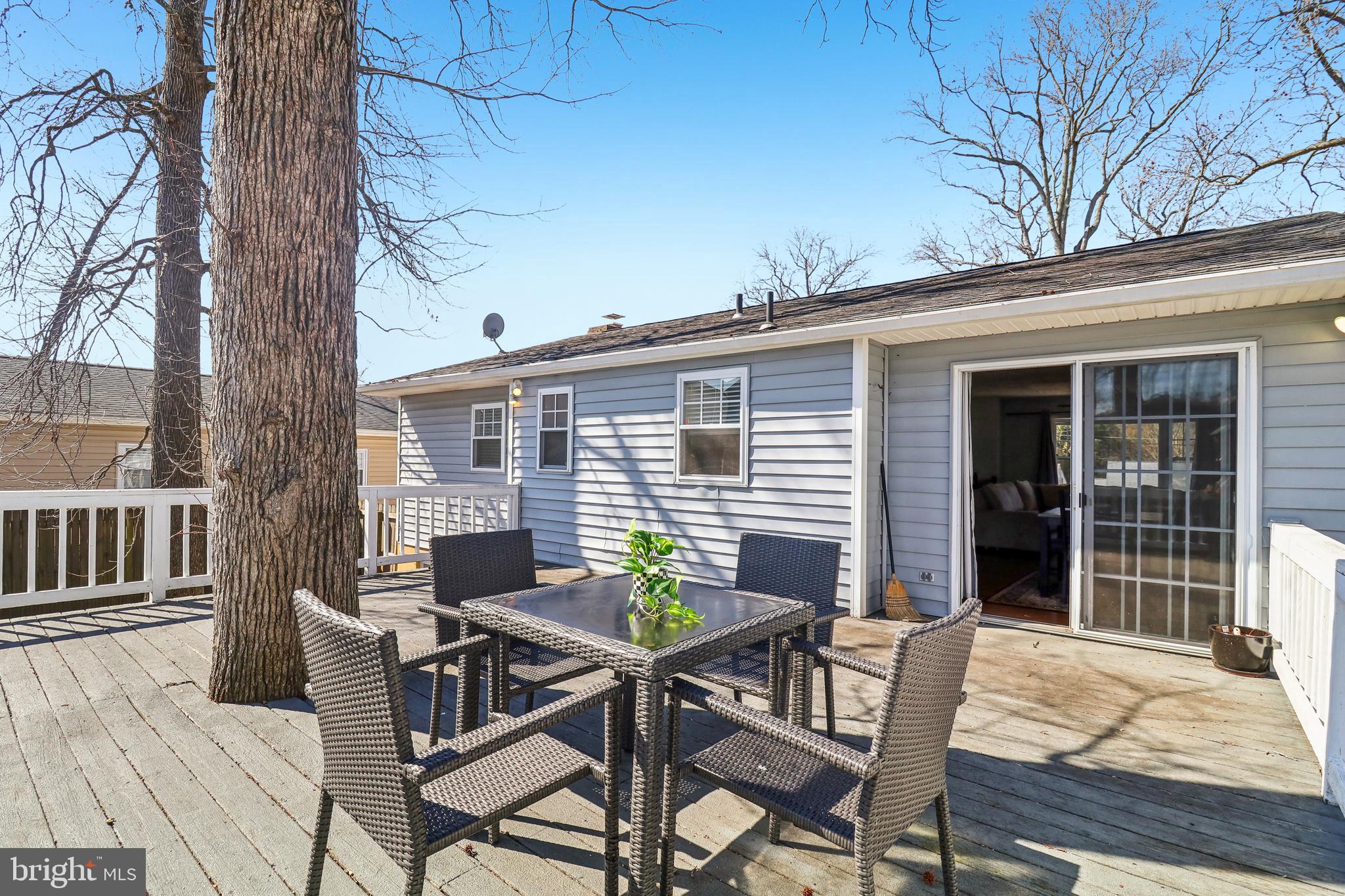 1809 Keymar Road Edgewater, MD 21037 - Photo 30 of 49 a view of a patio with table and chairs with wooden floor and fence