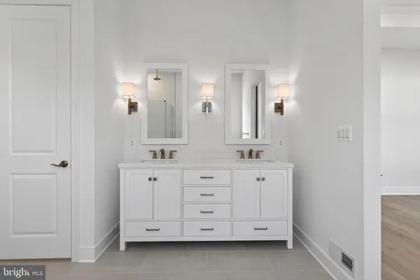 a spacious bathroom with a double vanity sink a mirror and a