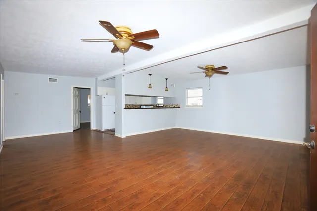 a view of a livingroom with a window and wooden floor