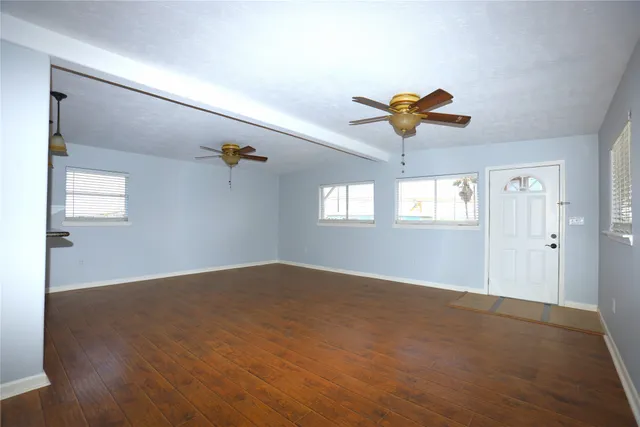 a view of a room with wooden floor and a ceiling fan