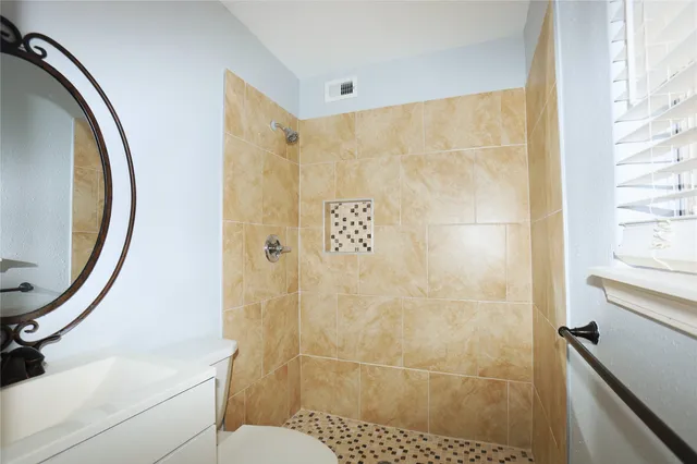 a view of empty room with wooden floor and ceiling fan